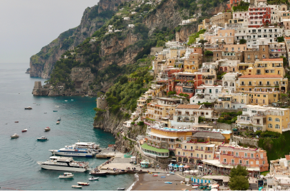 Family sitting together on a dock watching child splash in the water. 